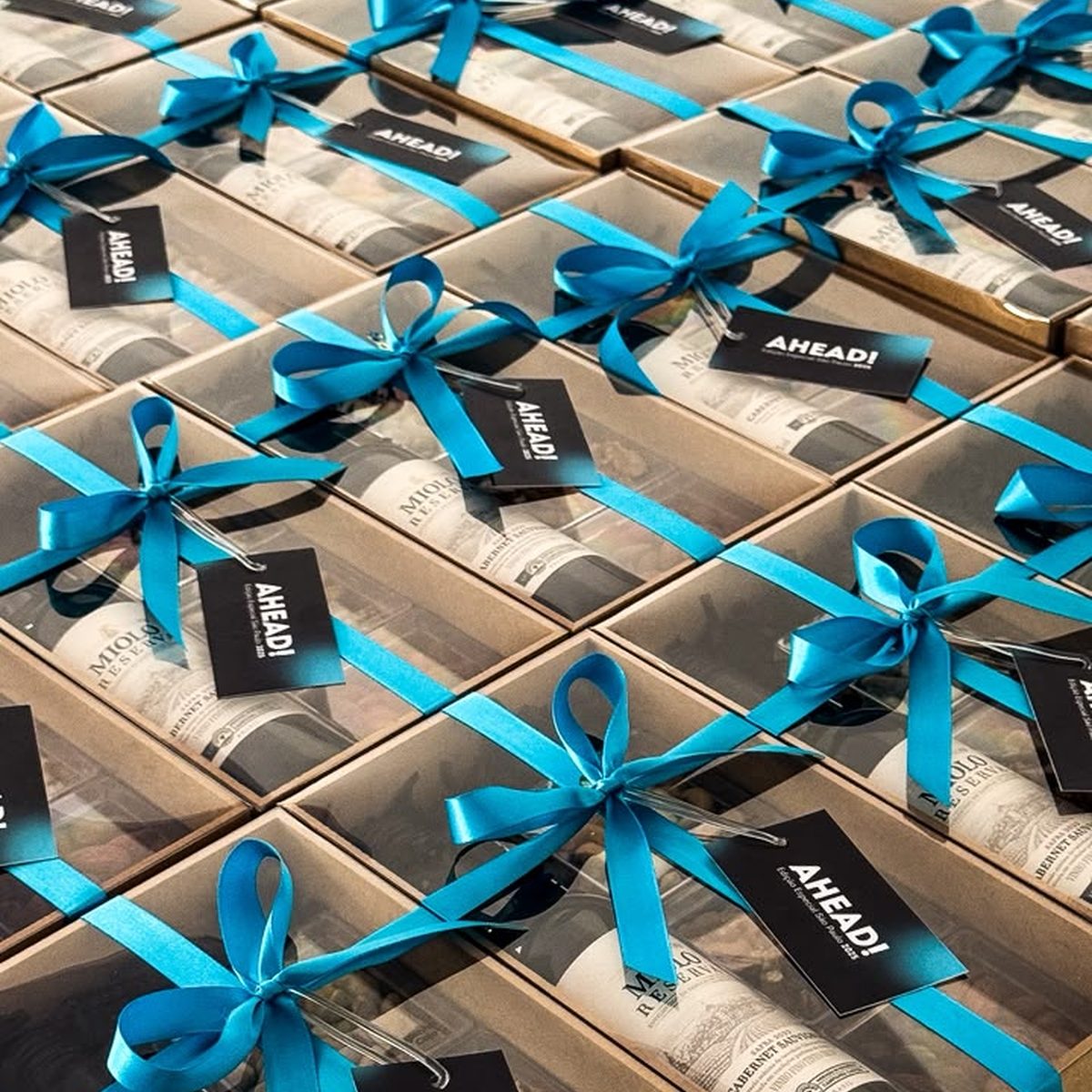 Produção em volume de boxes com vinho e fita azul da marca